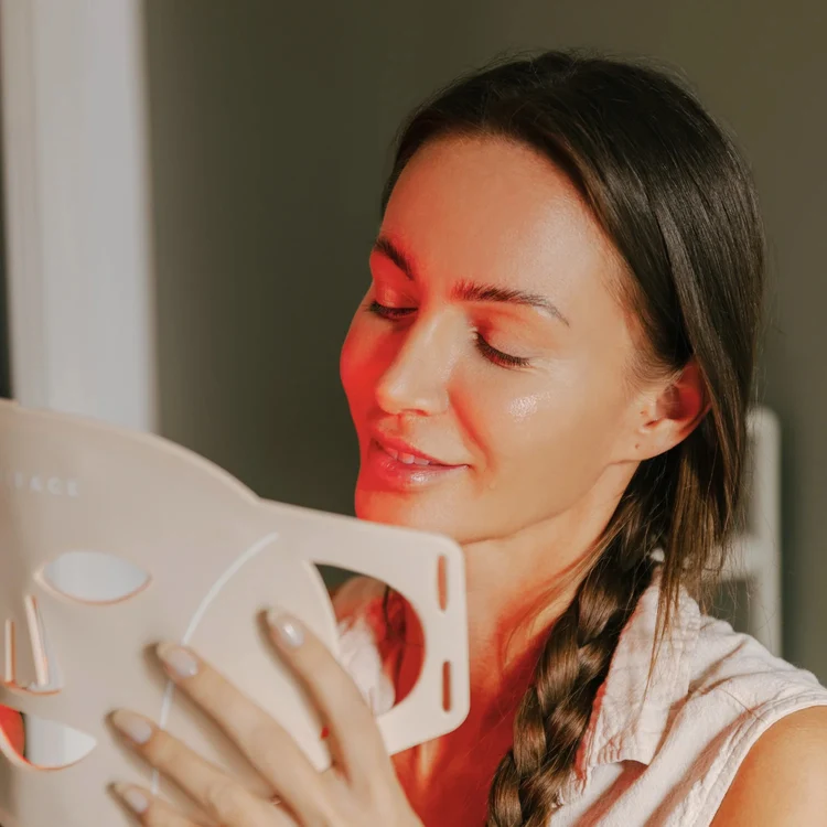 Närbild på Scandiface LED Mask i handen med varmt ljus