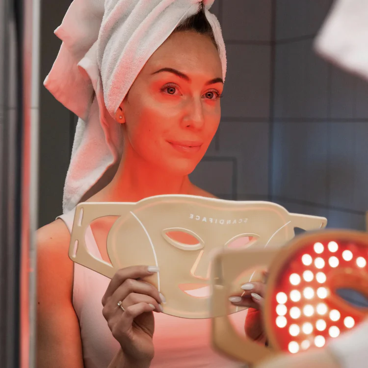 Scandiface LED Mask med tända röda dioder framför badrumsspegeln